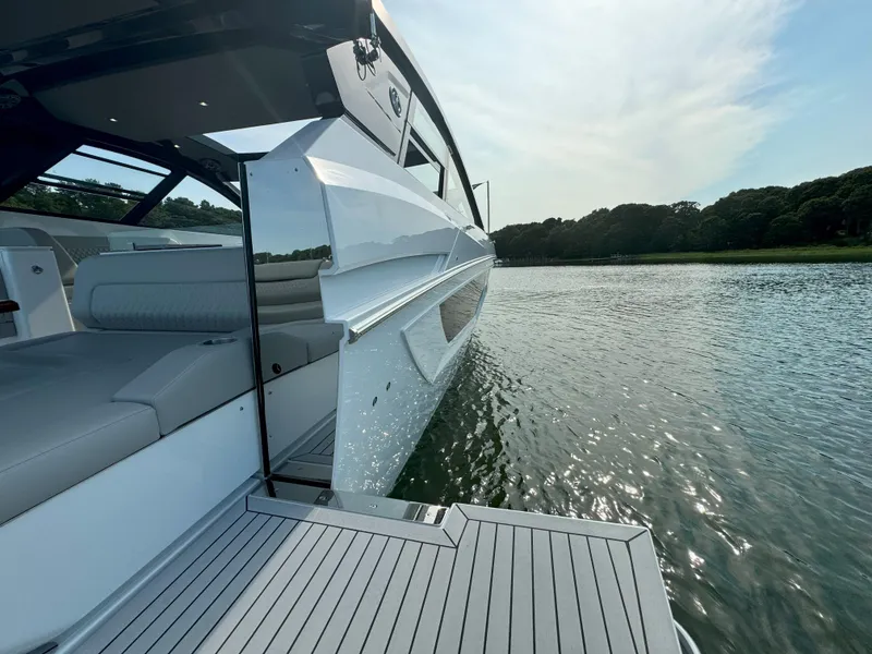 Slide: The Image of 2025 Cruisers Yachts 50 GLS Outboard on serene water, showcasing sleek design and luxurious deck. - 41