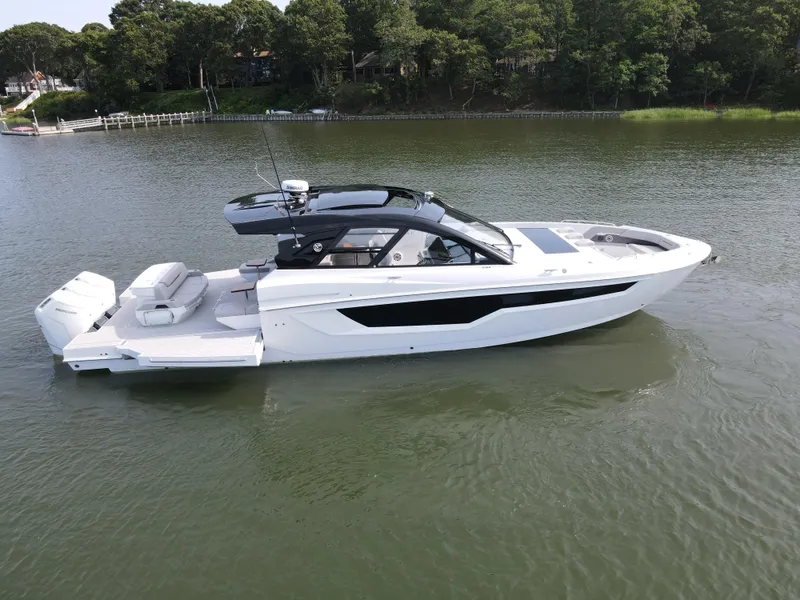 Slide: The Image of 2025 Cruisers Yachts 50 GLS Outboard luxury boat on calm water. - 2