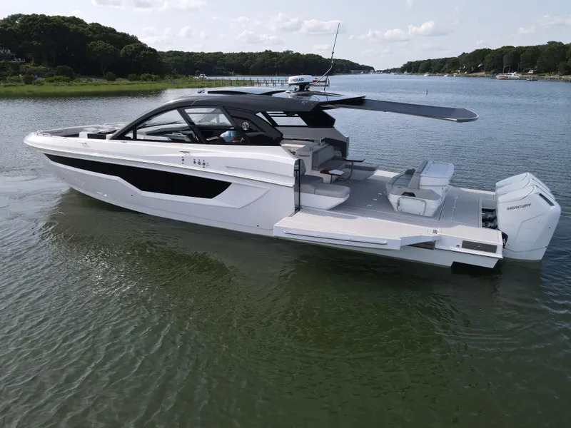 Slide: The Image of 2025 Cruisers Yachts 50 GLS Outboard luxury boat on calm water. - 22
