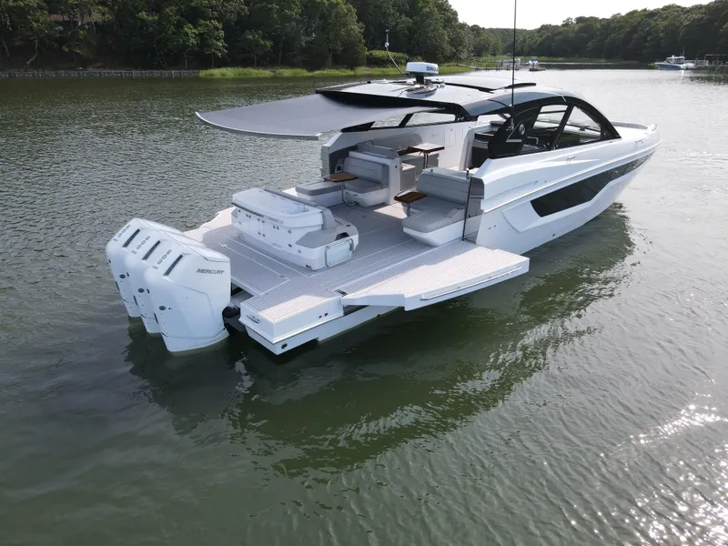 Slide: The Image of 2025 Cruisers Yachts 50 GLS Outboard luxury boat on calm water. - 24