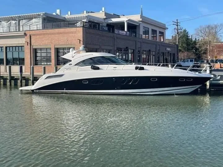 Slide: The Image of 2012 Sea Ray 540 Sundancer yacht docked by a waterfront building. - 2