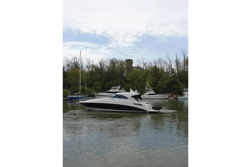 Slide: The Image of 2012 Sea Ray Sundancer 540 yacht cruising on a calm river with trees in the background. - 47