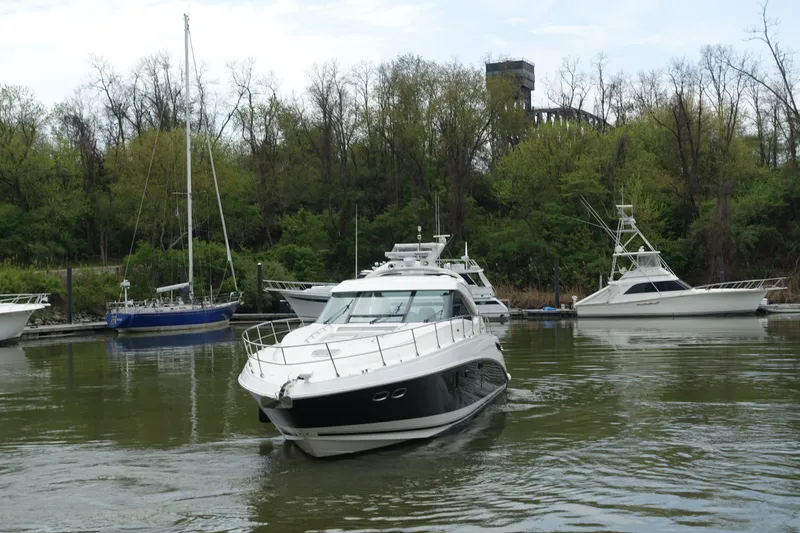 Slide: The Image of 2012 Sea Ray Sundancer 540 yacht cruising in a serene marina with lush greenery. - 48
