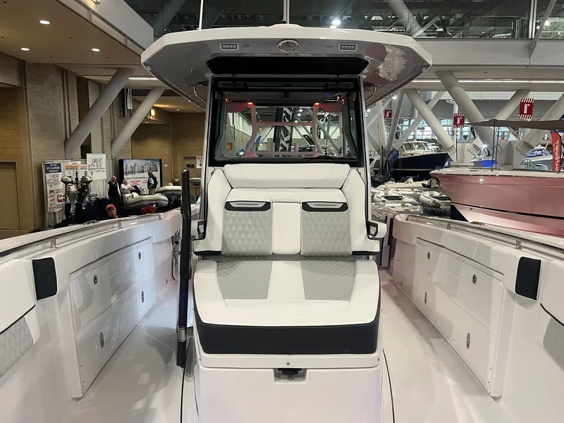Slide: The Image of 2023 Blackfin 332 CC boat interior at a showroom, showcasing sleek seating and modern design. - 26