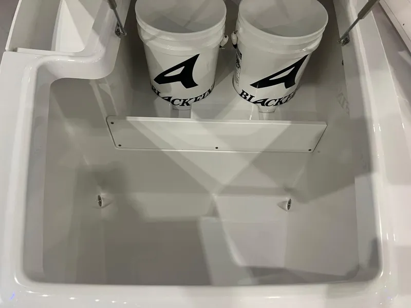 Slide: The Image of 2023 Blackfin 332 CC boat storage compartment with branded buckets. - 29