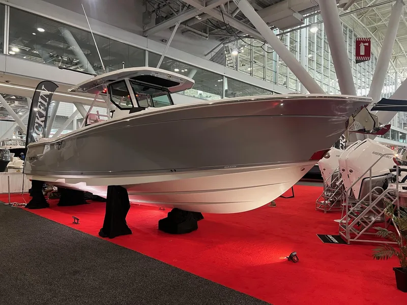 Slide: The Image of 2023 Blackfin 332 CC boat displayed indoors on red carpet. - 3