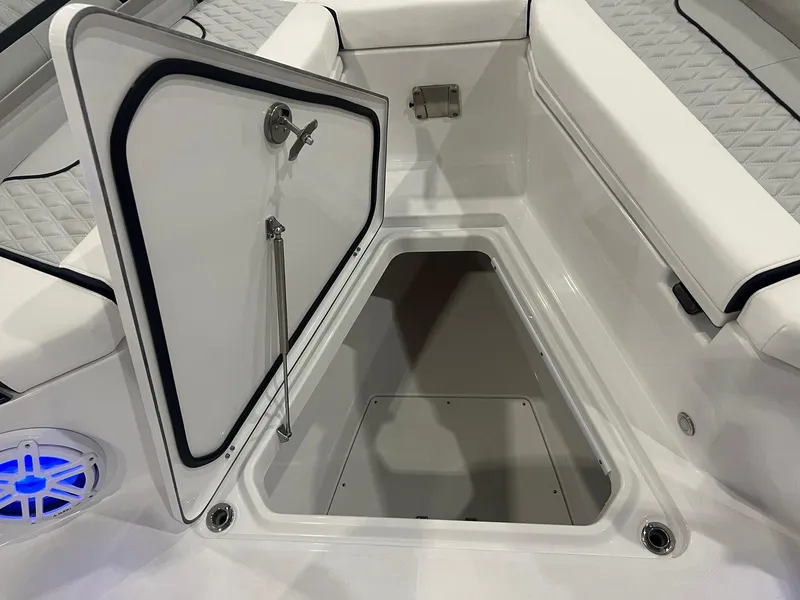 Slide: The Image of 2023 Blackfin 332 CC boat storage compartment with open hatch and blue speaker. - 30