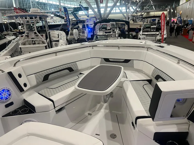 Slide: The Image of 2023 Blackfin 332 CC boat interior with seating and table at a boat show. - 39