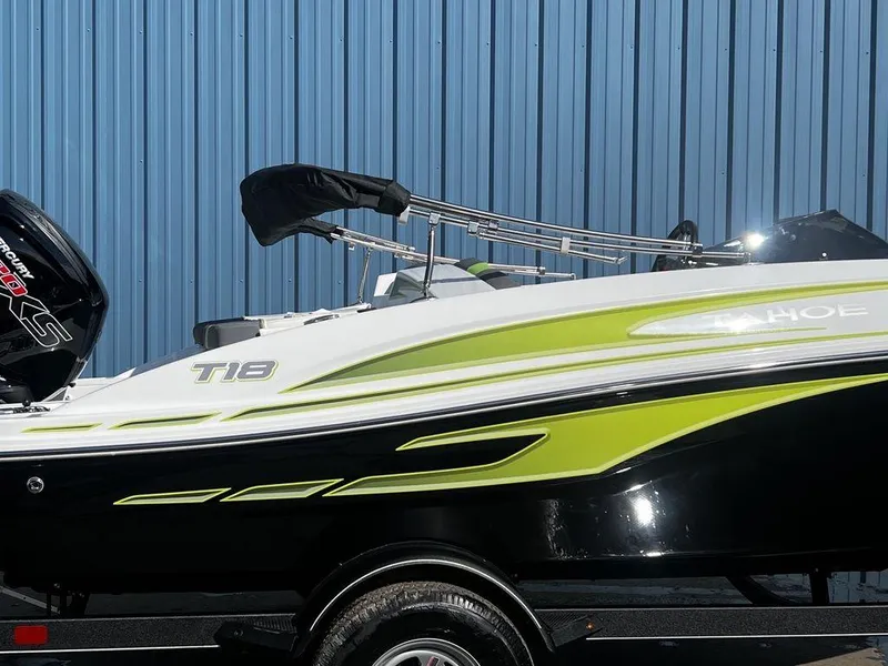 Slide: The Image of 2023 Tahoe T18 boat with green and black design against a blue wall. - 5