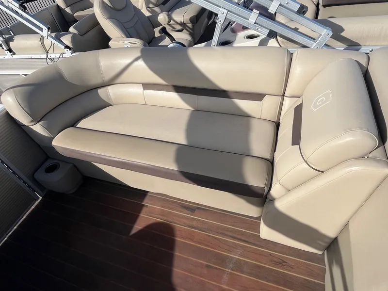 Slide: The Image of 2020 Sweetwater 2286 SB boat with beige seating on wooden deck. - 10