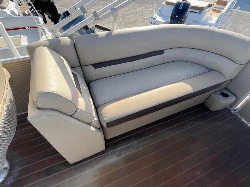 Slide: The Image of 2020 Sweetwater 2286 SB boat interior with beige seating and wooden flooring. - 11