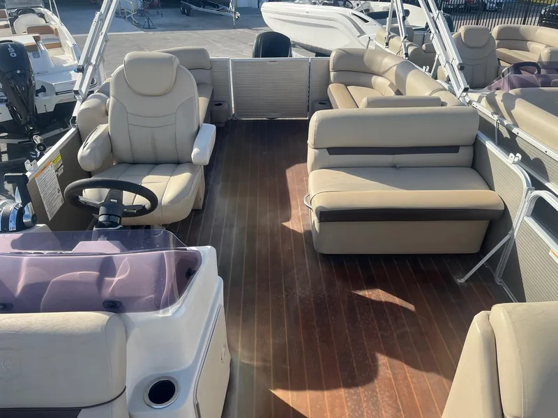 Slide: The Image of 2020 Sweetwater 2286 SB pontoon boat interior with beige seating and wood-style flooring. - 14