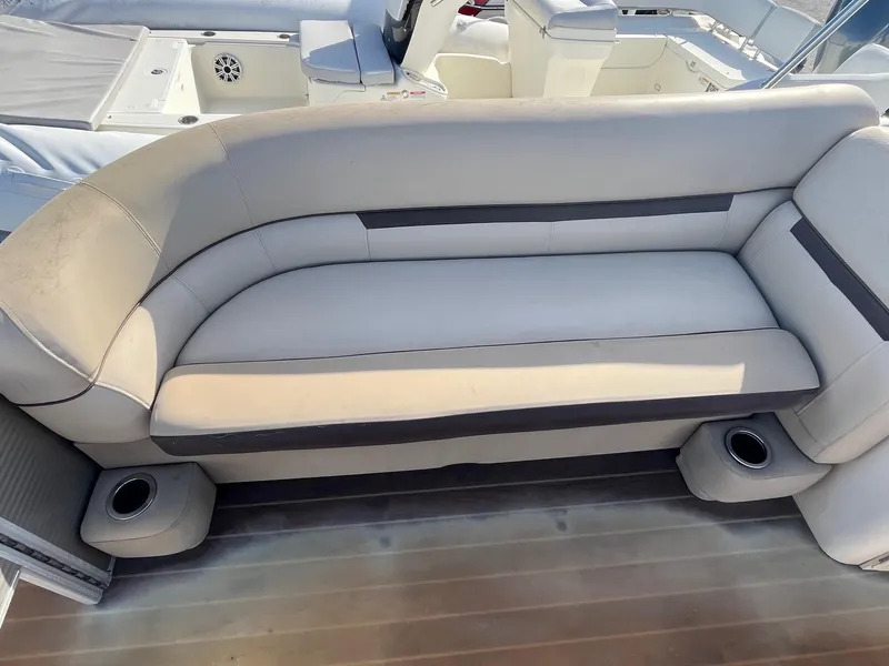 Slide: The Image of 2020 Sweetwater 2286 SB boat interior with beige seating and cup holders. - 15
