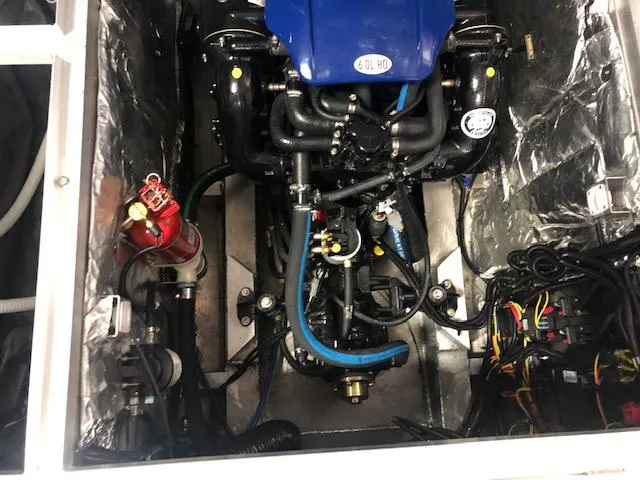 Slide: The Image of Engine compartment of a 2020 Montara 25' Surf Boss boat, featuring a blue engine and wiring. - 24