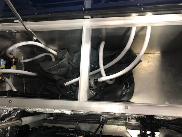 Slide: The Image of Interior view of 2020 Montara 25' Surf Boss boat with visible hoses and compartments. - 25