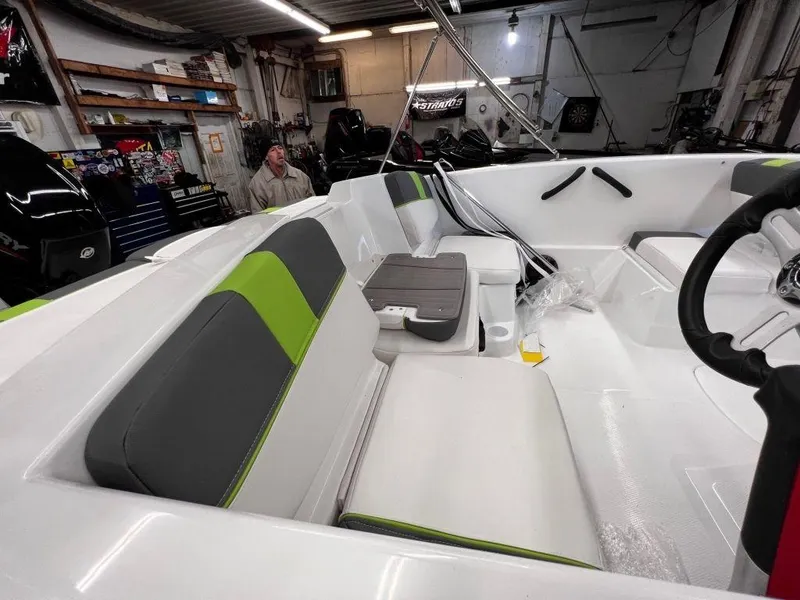 Slide: The Image of 2023 Tahoe T16 boat interior with green and gray seating in a workshop. - 4