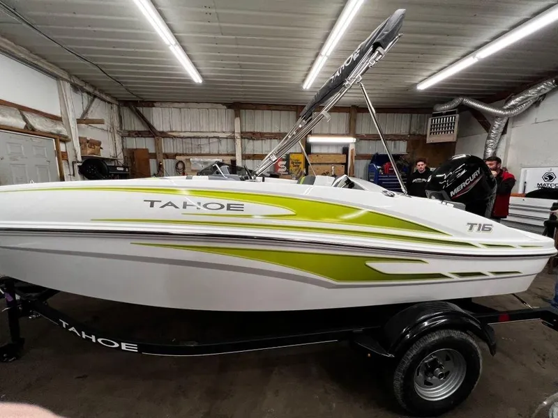 Slide: The Image of 2023 Tahoe T16 boat with green accents in a warehouse. - 6