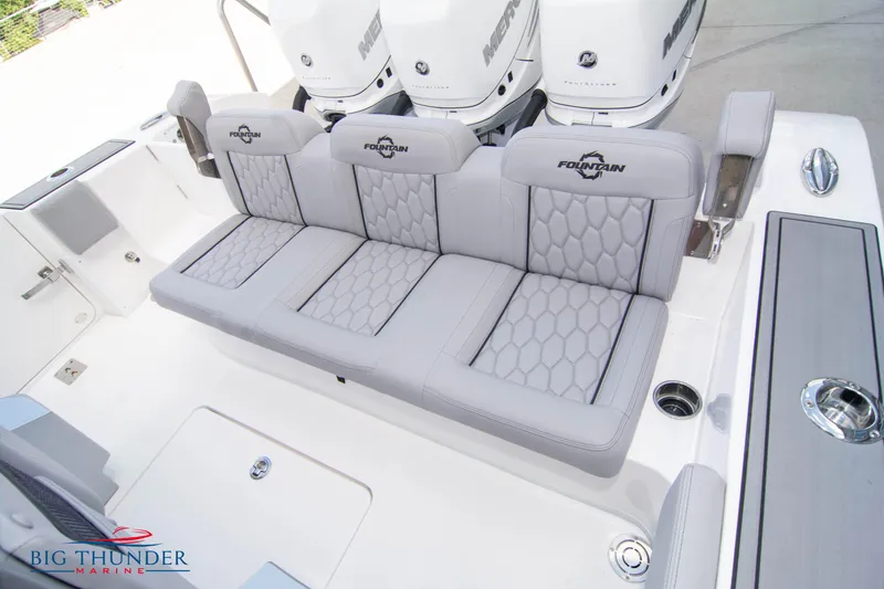 Slide: The Image of 2023 Fountain 38 SC boat with gray cushioned seating and triple Mercury engines. - 20
