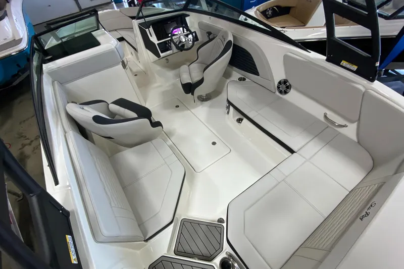 Slide: The Image of 2023 Sea Ray SPX 230 OB boat interior with white seating and modern dashboard. - 9