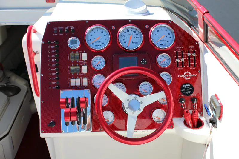 Slide: The Image of The image shows the red dashboard of a 2007 Fountain 42 Lightning boat with numerous gauges. - 32