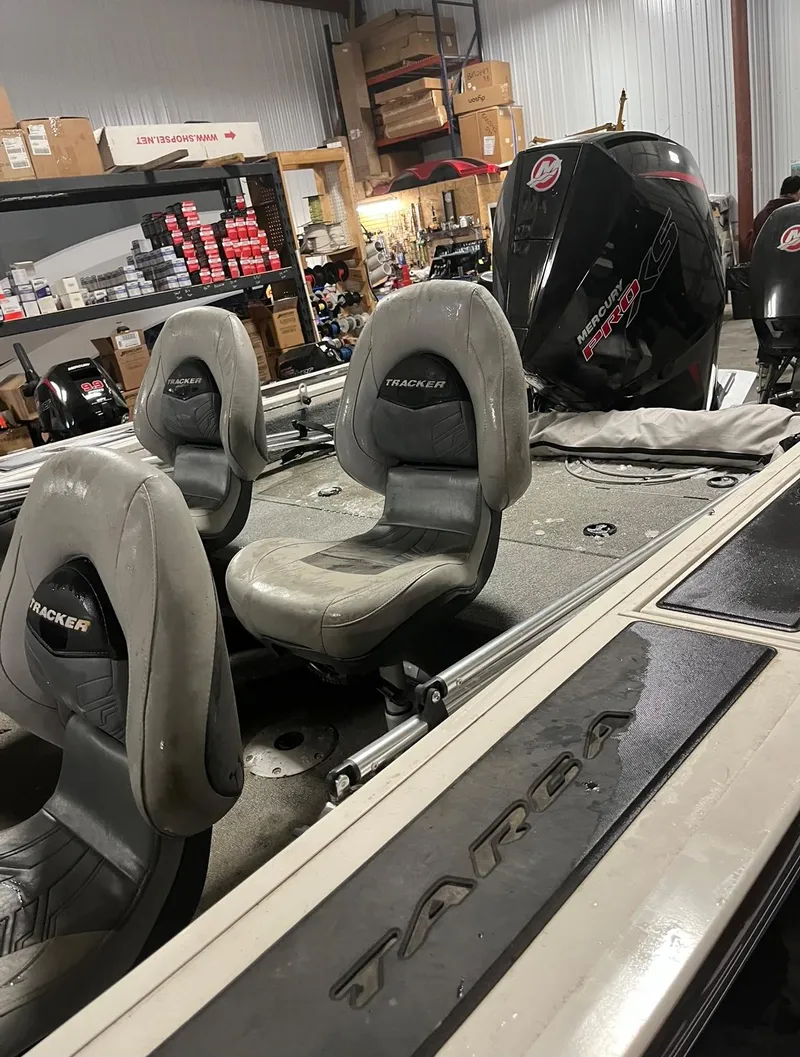 Slide: The Image of 2019 Tracker Targa V-19 Combo TE boat interior with seats and motor in a garage. - 4