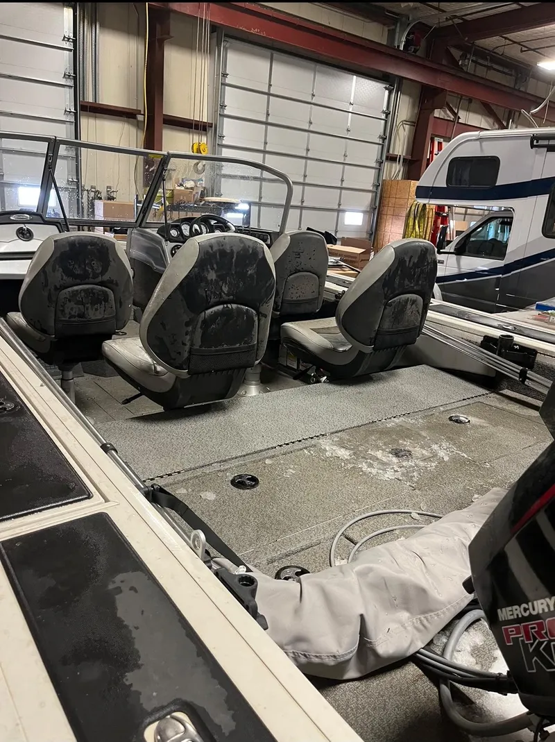 Slide: The Image of 2019 Tracker Targa V-19 Combo TE boat interior with seating and Mercury engine in a garage. - 9
