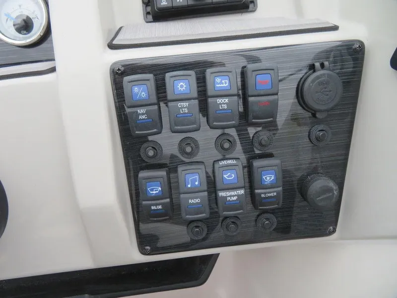 Slide: The Image of Control panel of a 2023 Starcraft SVX IO 210 boat with various switches. - 13