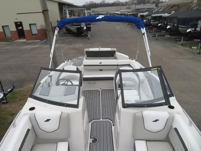 Slide: The Image of 2023 Starcraft SVX IO 210 boat with open deck and blue canopy. - 6