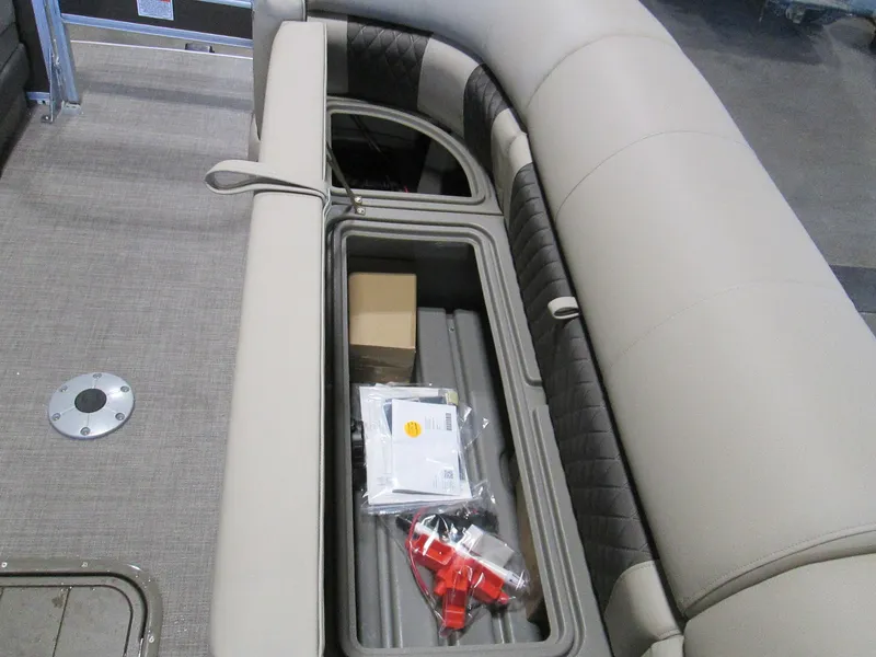 Slide: The Image of 2023 Sun Tracker SportFish 22 XP3 boat interior storage compartment with beige and black seating. - 18