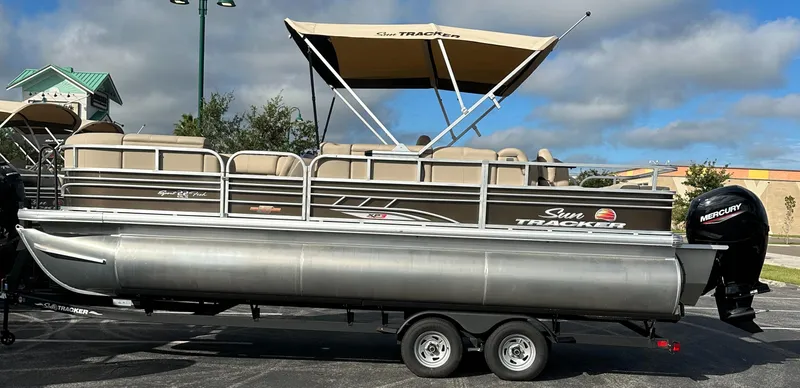 The Image of 2023 Sun Tracker SportFish 22 XP3 pontoon boat on trailer, side view. - 0