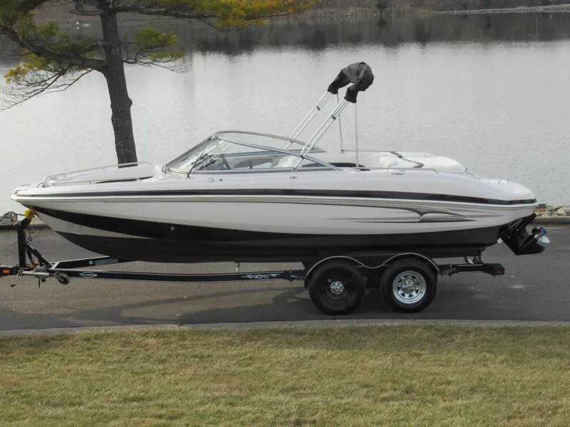 Slide: The Image of 2007 Tahoe Q8i boat on trailer by a lake. - 0