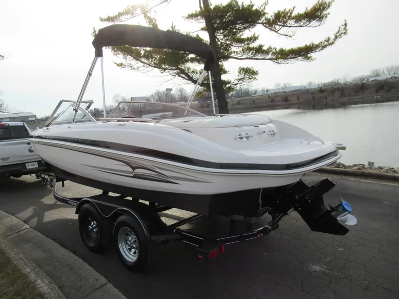 Slide: The Image of 2007 Tahoe Q8i boat on a trailer by a lakeside road. - 1