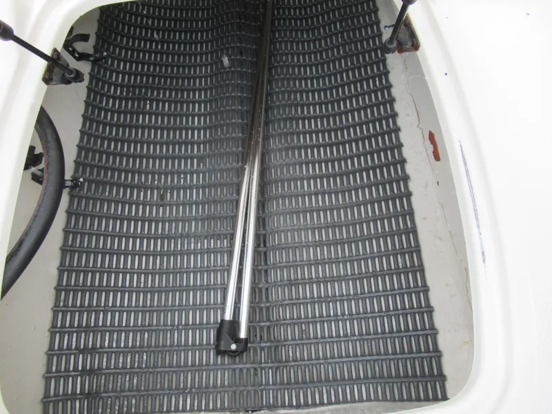 Slide: The Image of 2007 Tahoe Q8i boat storage compartment with black mat and metal rod. - 14