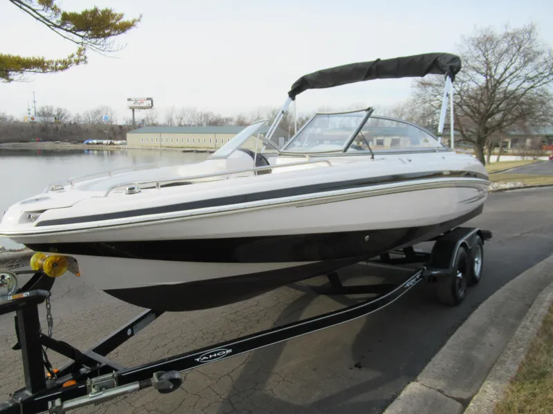 Slide: The Image of 2007 Tahoe Q8i boat on trailer by a lake. - 8
