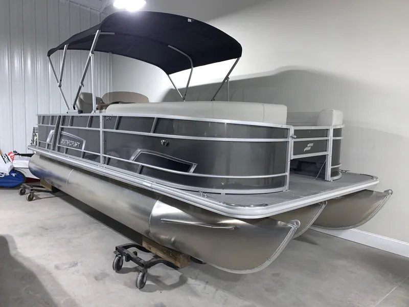 Slide: The Image of 2024 Starcraft EX22 FD pontoon boat in a showroom. - 2