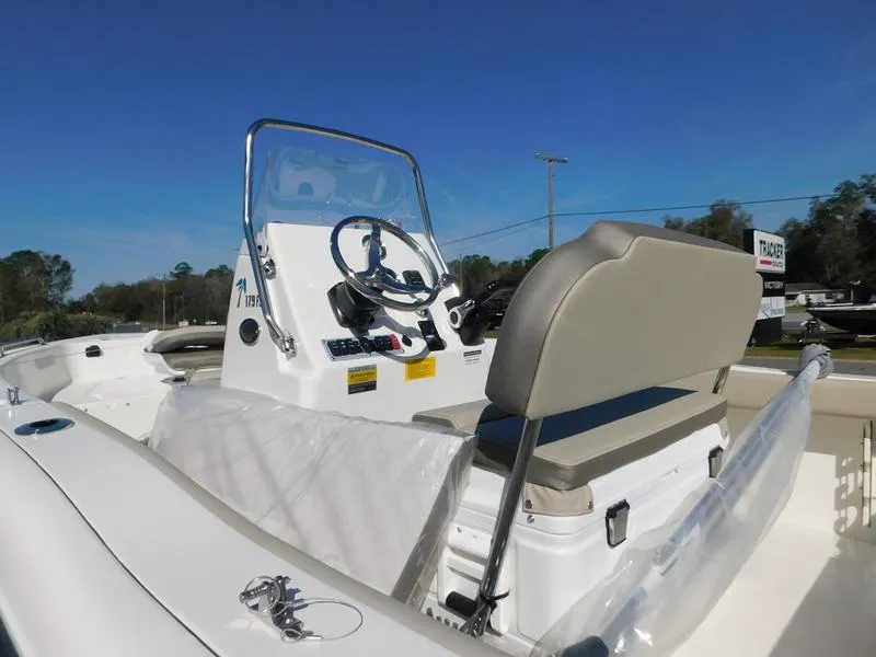 Slide: The Image of 2023 Key West 179FS boat console and seating area under clear blue sky. - 9