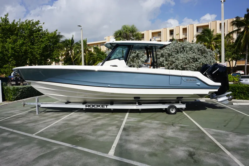The Image of 2024 Boston Whaler 360 Outrage boat on a trailer in a parking lot. - 1