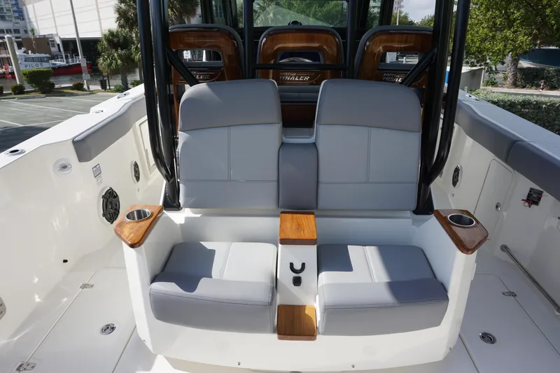 Slide: The Image of 2024 Boston Whaler 360 Outrage boat seating area with cup holders and modern design. - 11