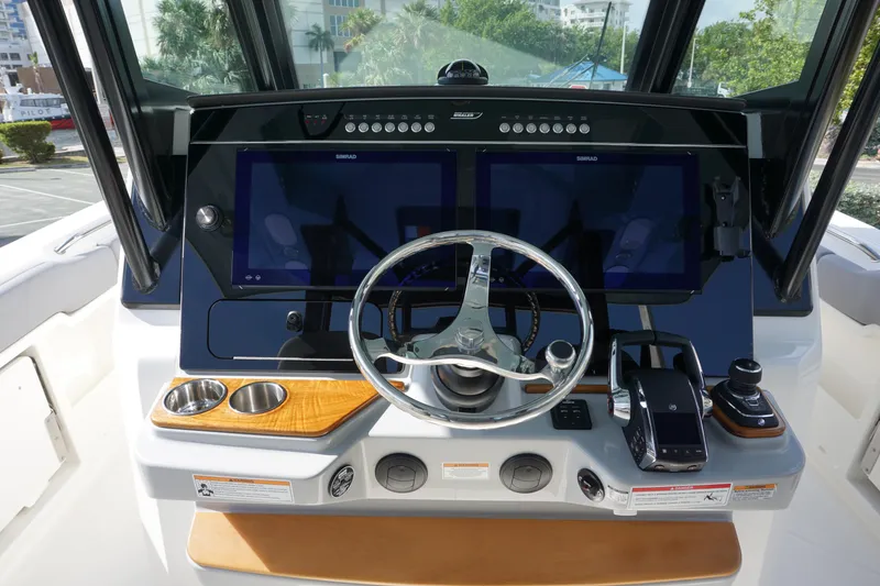 Slide: The Image of 2024 Boston Whaler 360 Outrage helm with dual screens and modern controls. - 12