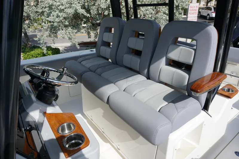 Slide: The Image of 2024 Boston Whaler 360 Outrage boat cockpit with plush seating and modern steering console. - 16