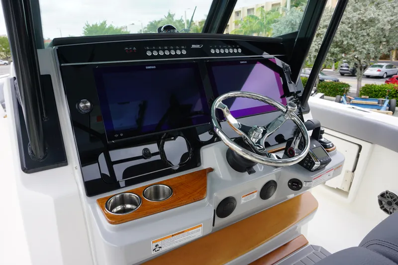Slide: The Image of 2024 Boston Whaler 360 Outrage helm with dual screens and modern controls. - 43