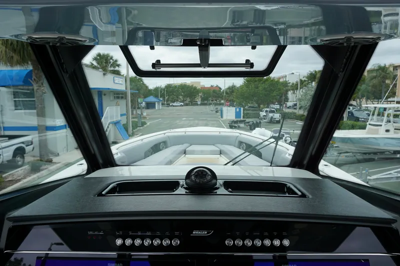 Slide: The Image of 2024 Boston Whaler 360 Outrage helm view with marina background. - 47