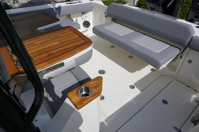 Slide: The Image of Boston Whaler 360 Outrage 2024 boat interior with teak accents and cushioned seating. - 6