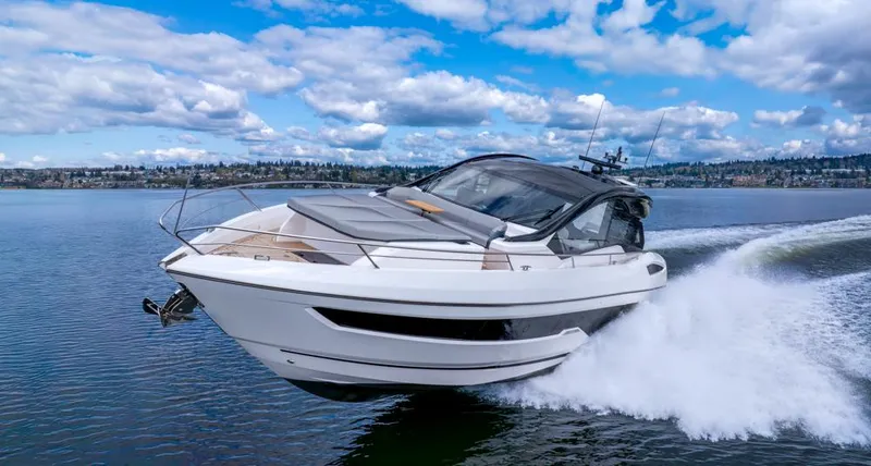 Slide: The Image of 2025 Sunseeker Predator 55 yacht cruising on a serene lake under a partly cloudy sky. - 11