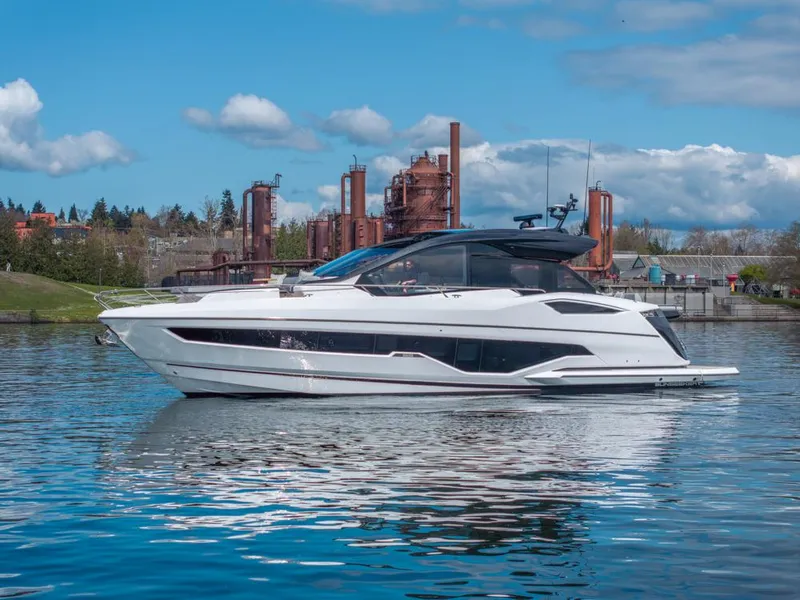 Slide: The Image of 2025 Sunseeker Predator 55 yacht on calm water with industrial backdrop. - 13