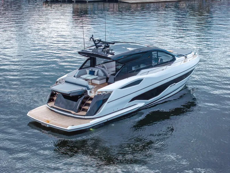 Slide: The Image of 2025 Sunseeker Predator 55 yacht on calm water, rear view showcasing deck and seating area. - 18