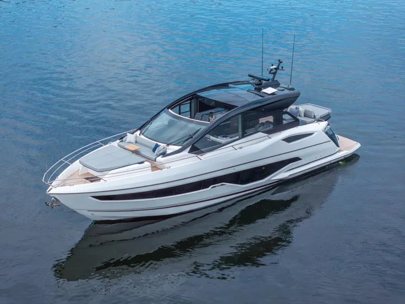 Slide: The Image of 2025 Sunseeker Predator 55 yacht on calm water, industrial backdrop, blue sky. - 23