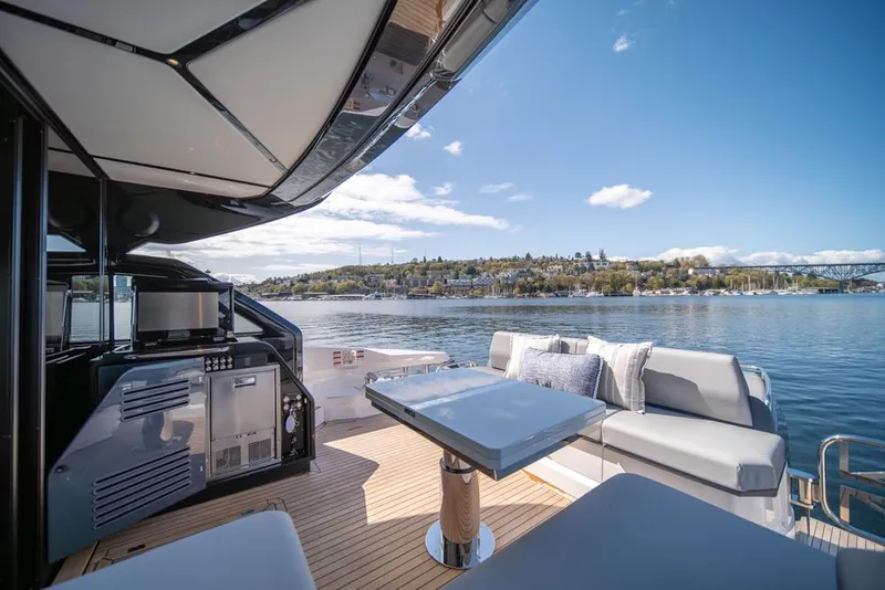 Slide: The Image of Luxury Sunseeker Predator 55 yacht deck with seating, table, and scenic water view, 2025 model. - 3