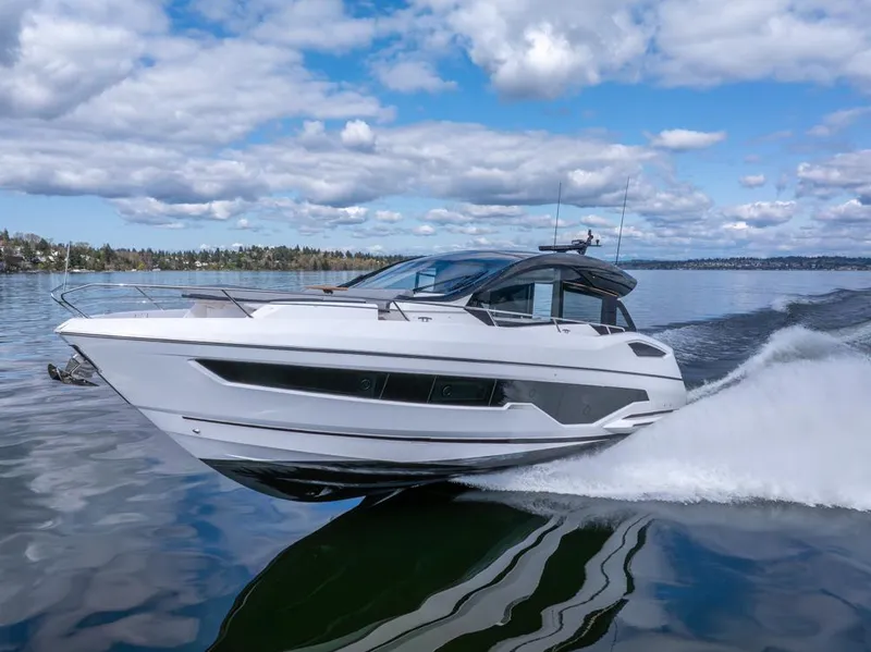 Slide: The Image of 2025 Sunseeker Predator 55 yacht cruising on a calm lake under a partly cloudy sky. - 8