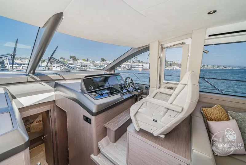 Slide: The Image of Interior helm of 2025 Sunseeker Manhattan 68 yacht, featuring modern controls and luxurious seating. - 48